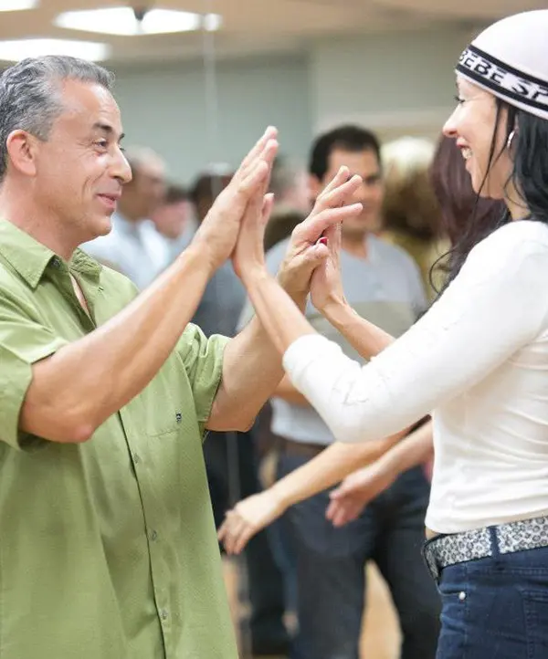 man and woman happily dancing in a salsa class