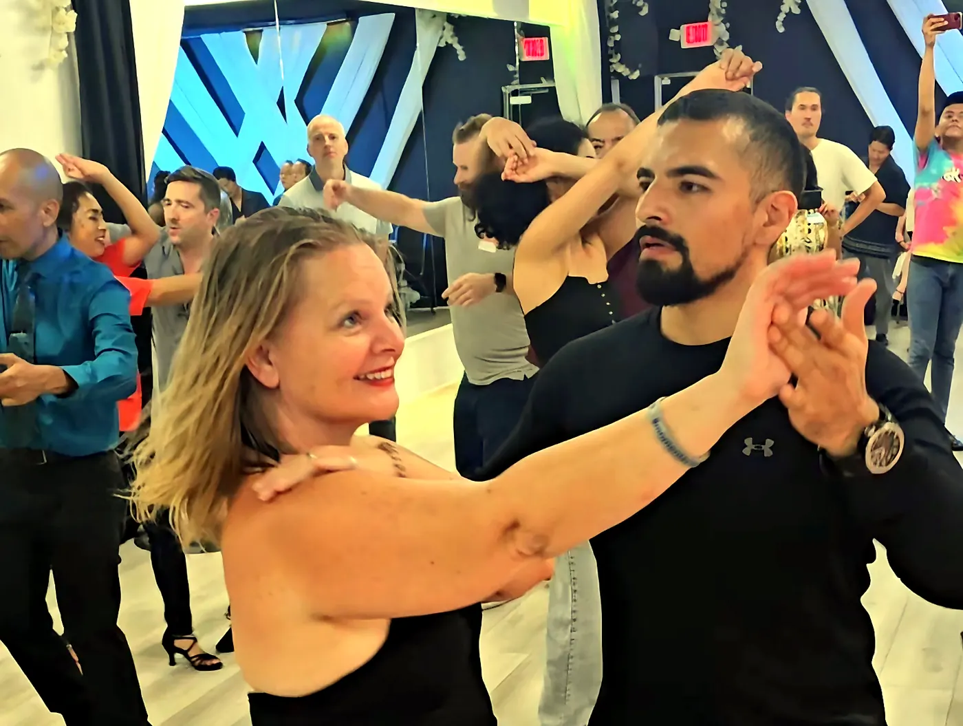 Two students practicing a partner turn at OC Salsa
